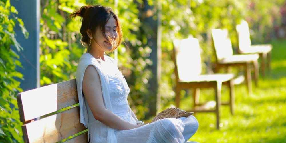 A Female meditating on a park bench